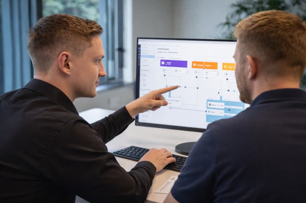 Scaile-udvikler sidder sammen med kundens operations-ansvarlige og gennemgår et automationsflow på skærmen.